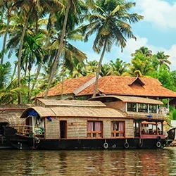 A peaceful view of Kerala's backwaters with a houseboat sailing through palm trees